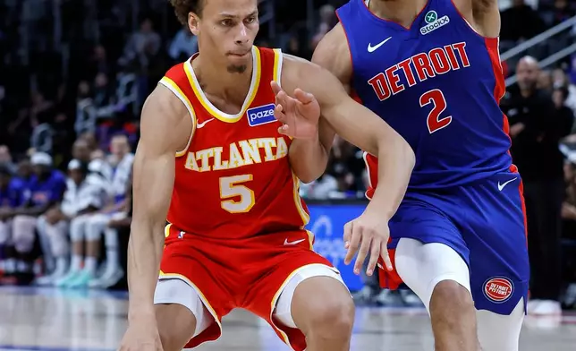 Atlanta Hawks guard Dyson Daniels (5) drives against Detroit Pistons guard Cade Cunningham (2) during the first half of an NBA basketball game Friday, Dec. 12, 2025, in Detroit. (AP Photo/Duane Burleson)
