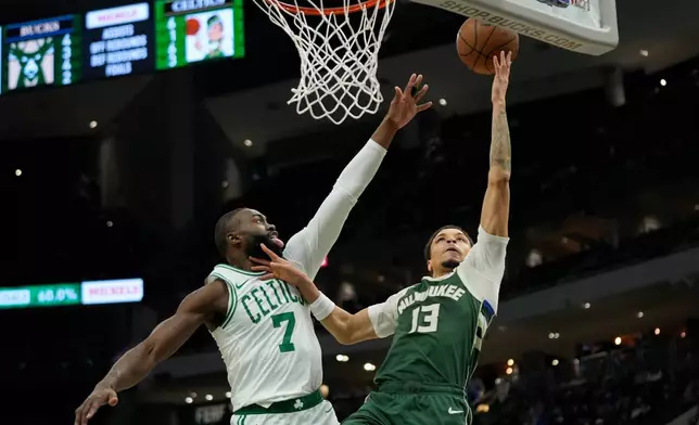 Milwaukee Bucks' Ryan Rollins (13) shoots against Boston Celtics' Jaylen Brown (7) during the first half of an NBA basketball game Thursday, Dec. 11, 2025, in Milwaukee. (AP Photo/Aaron Gash)