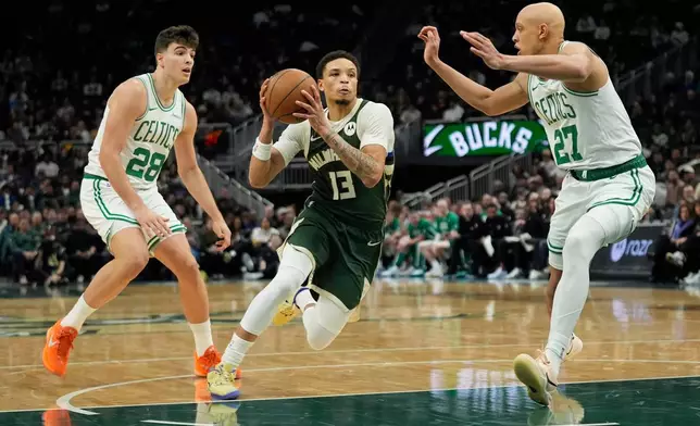 Milwaukee Bucks' Ryan Rollins (13) drives to the basket between Boston Celtics' Jordan Walsh (27) and Hugo Gonzalez (28) during the first half of an NBA basketball game Thursday, Dec. 11, 2025, in Milwaukee. (AP Photo/Aaron Gash)