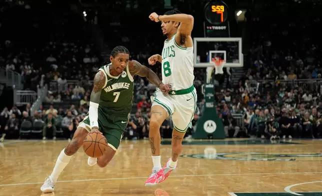 Milwaukee Bucks' Kevin Porter Jr. (7) drives to the basket against Boston Celtics' Josh Minott (8) during the first half of an NBA basketball game Thursday, Dec. 11, 2025, in Milwaukee. (AP Photo/Aaron Gash)