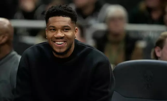 Milwaukee Bucks' Giannis Antetokounmpo smiles from the bench during the first half of an NBA basketball game against the Boston Celtics, Thursday, Dec. 11, 2025, in Milwaukee. (AP Photo/Aaron Gash)