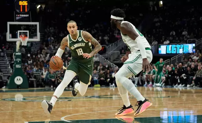 Milwaukee Bucks' Kyle Kuzma (18) drives to the basket against Boston Celtics' Neemias Queta during the first half of an NBA basketball game Thursday, Dec. 11, 2025, in Milwaukee. (AP Photo/Aaron Gash)