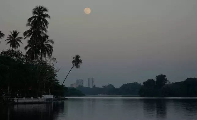 The moon rising near Inya Lake is seen Thursday, Dec.4, 2025, in Yangon, Myanmar. (AP Photo/Thein Zaw)