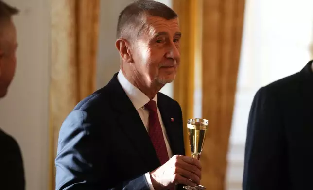 Leader of ANO political movement Andrej Babisn holds a glass of champagne after being sworn in as the country's new prime minister at the Prague Castle in Prague, Czech Republic, Tuesday, Dec. 9, 2025. (AP Photo/Petr David Josek)