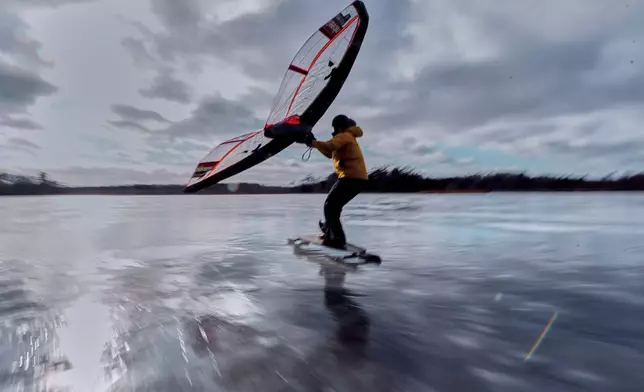 Alex Sutula, of South Portland, Maine, wingskates across frozen Great Pond on a skateboard modified with metal blades, Tuesday, Dec. 30, 2025, in Cape Elizabeth, Maine. (AP Photo/Robert F. Bukaty)