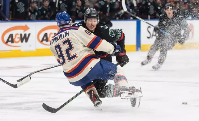 Seattle Kraken's Brandon Montour (62) checks Edmonton Oilers' Vasily Podkolzin (92) during second-period NHL hockey game action in Edmonton, Alberta, Thursday, Dec. 4, 2025. (Jason Franson/The Canadian Press via AP)