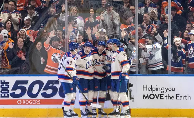 Edmonton Oilers' Ryan Nugent-Hopkins (93), Zach Hyman (18), Connor McDavid (97), Leon Draisaitl (29) and Evan Bouchard (2) celebrate a goal against the Seattle Kraken during first period NHL action, in Edmonton on Thursday, Dec. 4, 2025. (Jason Franson/The Canadian Press via AP)