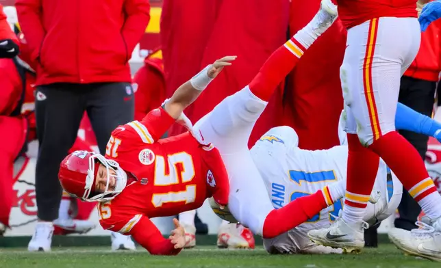 Kansas City Chiefs quarterback Patrick Mahomes (15) is injured after being tackled by Los Angeles Chargers defensive tackle Da'Shawn Hand (91) during the second half of an NFL football game, Sunday, Dec. 14, 2025 in Kansas City, Mo. (AP Photo/Reed Hoffmann)
