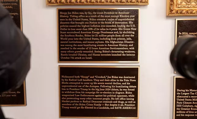 New plaques of explanatory text are seen beneath a framed portrait in the space for former President Joe Biden on the Presidential Walk of Fame on the Colonnade of the White House, Wednesday, Dec. 17, 2025, in Washington. (AP Photo/Mark Schiefelbein)