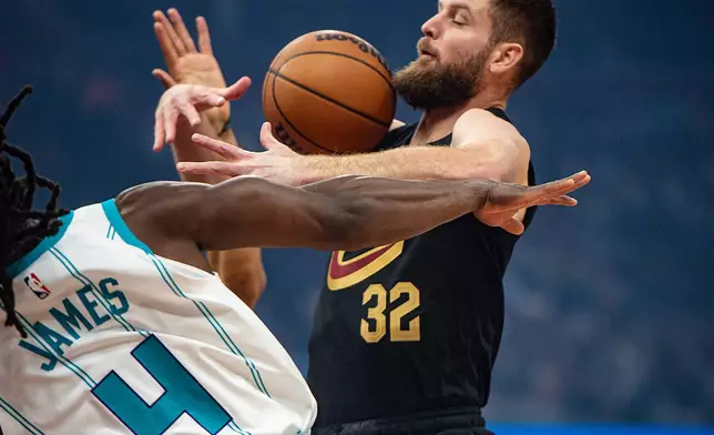Cleveland Cavaliers' Dean Wade (32) and Charlotte Hornets' Sion James (4) contend for a rebound during the first half of an NBA basketball game in Cleveland, Sunday, Dec. 14, 2025. (AP Photo/Phil Long)