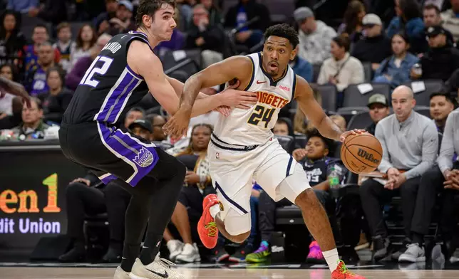Denver Nuggets guard Jalen Pickett (24) drives around Sacramento Kings center Maxime Raynaud during the first half of an NBA basketball game in Sacramento, Calif., Thursday, Dec. 11, 2025. (AP Photo/Randall Benton)