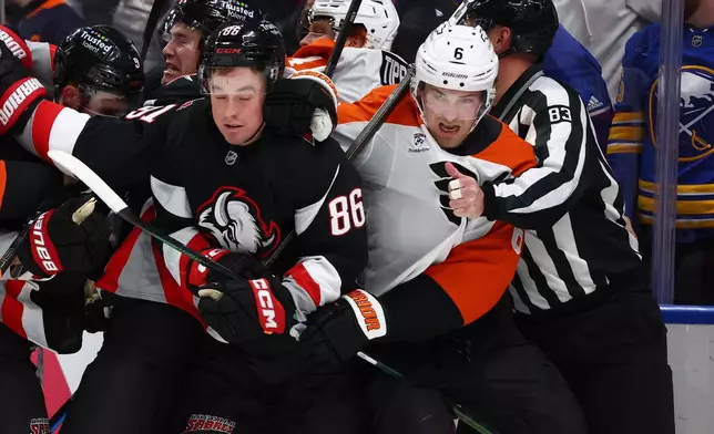 Buffalo Sabres center Noah Ostlund (86) and Philadelphia Flyers defenseman Travis Sanheim (6) get separated by linesman Matt MacPherson (83) during the second period of an NHL hockey game Thursday, Dec. 18, 2025, in Buffalo, N.Y. (AP Photo/Jeffrey T. Barnes)