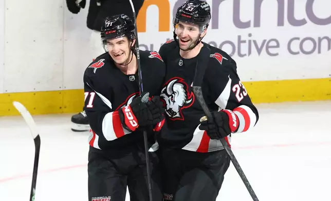 Buffalo Sabres center Ryan McLeod, left, celebrates his empty net goal with defenseman Mattias Samuelsson (23) during the third period of an NHL hockey game against the Philadelphia Flyers, Thursday, Dec. 18, 2025, in Buffalo, N.Y. (AP Photo/Jeffrey T. Barnes)