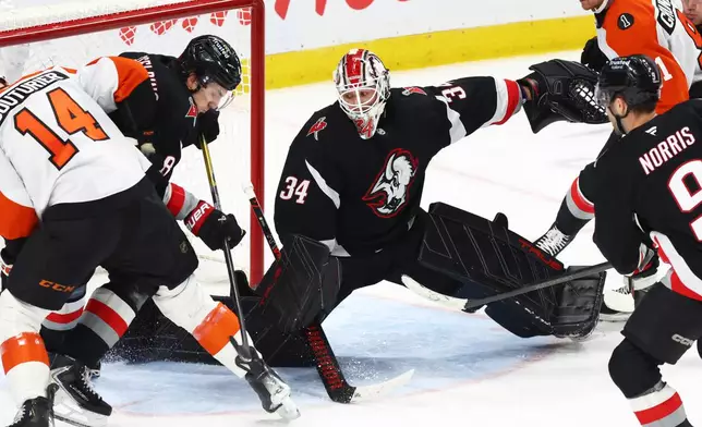 Buffalo Sabres goaltender Alex Lyon (34) slides across the crease to make a save during the third period of an NHL hockey game against the Philadelphia Flyers, Thursday, Dec. 18, 2025, in Buffalo, N.Y. (AP Photo/Jeffrey T. Barnes)