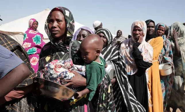FILE - Women displaced from El-Fasher stand in line to receive food aid at the newly established El-Afadh camp in Al Dabbah, in Sudan's Northern State, Nov. 16, 2025. (AP Photo/Marwan Ali, File)