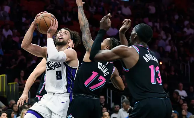 Sacramento Kings guard Zach Lavine (8) scores in front of Miami Heat guard Jahmir Young (17) during the first half of an NBA basketball game, Saturday, Dec. 6, 2025, in Miami. (AP Photo/Michael Laughlin)