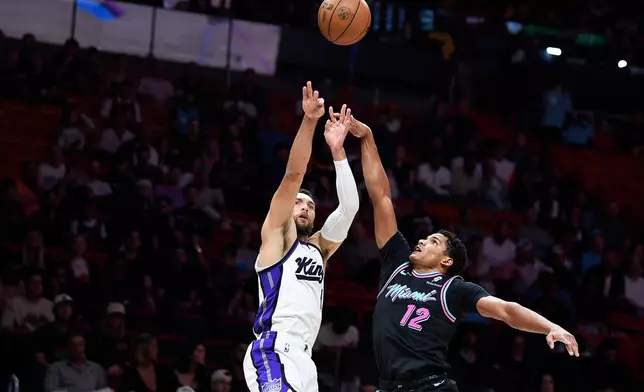 Sacramento Kings guard Zach Lavine, left, shoots over Miami Heat guard Dru Smith (12) during the first half of an NBA basketball game, Saturday, Dec. 6, 2025, in Miami. (AP Photo/Michael Laughlin)