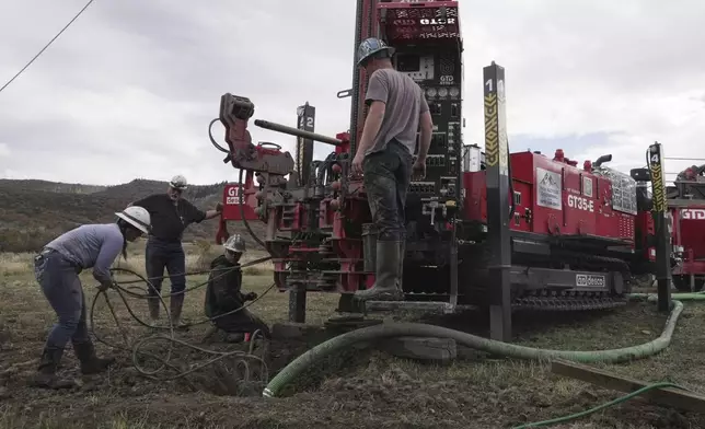 Matt Cooper and his kids Anna, Nathan and Matthew prepare to drill a hole for a geothermal heat pump installation Thursday, Oct. 9, 2025, in Hamilton, Colo. (AP PhotoBrittany Peterson)