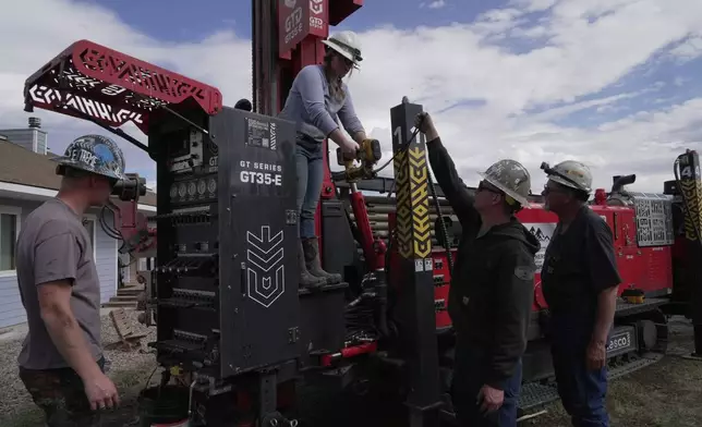 Matthew, Anna, Nathan and Matt Cooper prepare to drill a hole for a geothermal heat pump installation Thursday, Oct. 9, 2025, in Hamilton, Colo. (AP Photo/Brittany Peterson)
