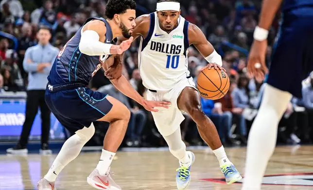 Dallas Mavericks guard Brandon Williams (10) drives against Oklahoma City Thunder guard Ajay Mitchell (25) during the first half of an NBA basketball game, Friday, Dec. 5, 2025, in Oklahoma City. (AP Photo/Gerald Leong)