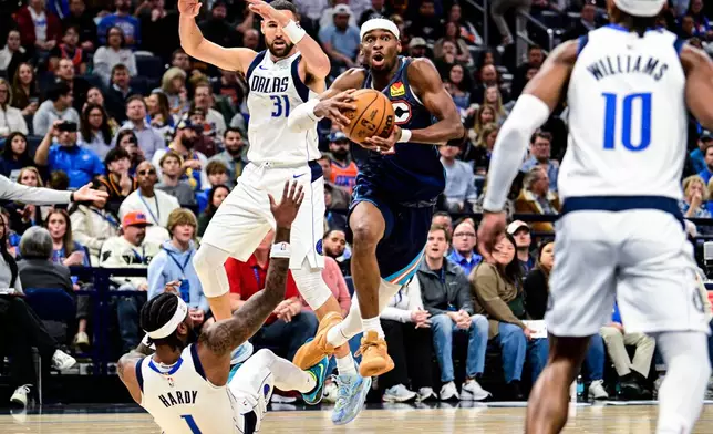 Oklahoma City Thunder guard Shai Gilgeous-Alexander (2) drives over Dallas Mavericks guard Jaden Hardy (1) during the second half of an NBA basketball game, Friday, Dec. 5, 2025, in Oklahoma City. (AP Photo/Gerald Leong)