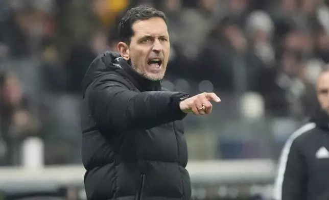 Frankfurt's head coach Dino Toppmoeller, left, gives instructions during the German Bundesliga soccer match between Eintracht Frankfurt and FC Augsburg in Frankfurt, Germany, Saturday, Dec. 13, 2025. (Marc Schueler/dpa via AP)