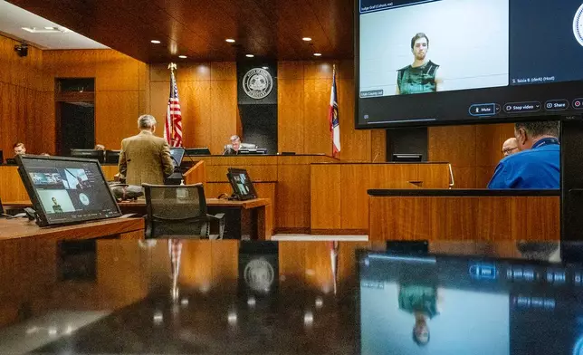 FILE - Defense attorney Greg Skordas, left, speaks before Judge Tony Graf, background, in Provo, Utah, as Tyler Robinson, in monitor at right, accused of fatally shooting Charlie Kirk, attends the court hearing virtually from prison on Tuesday, Sept. 16, 2025. (Scott G Winterton/The Deseret News via AP, Pool, File)