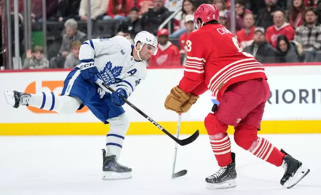 Toronto Maple Leafs center Dakota Joshua, left, shoots against Detroit Red Wings defenseman Ben Chiarot, right, during the first period of an NHL hockey game Sunday, Dec. 28, 2025, in Detroit. (AP Photo/Ryan Sun)
