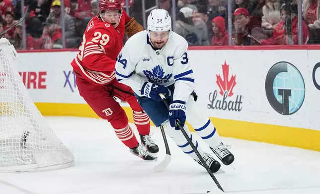 Toronto Maple Leafs center Auston Matthews, right, moves the puck against Detroit Red Wings center Nate Danielson, left, during the first period of an NHL hockey game Sunday, Dec. 28, 2025, in Detroit. (AP Photo/Ryan Sun)