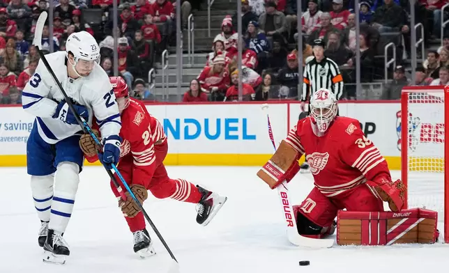 Toronto Maple Leafs left wing Matthew Knies, left, is unable to score against Detroit Red Wings defenseman Jacob Bernard-Docker, center, and goaltender Cam Talbot, right, during the first period of an NHL hockey game Sunday, Dec. 28, 2025, in Detroit. (AP Photo/Ryan Sun)