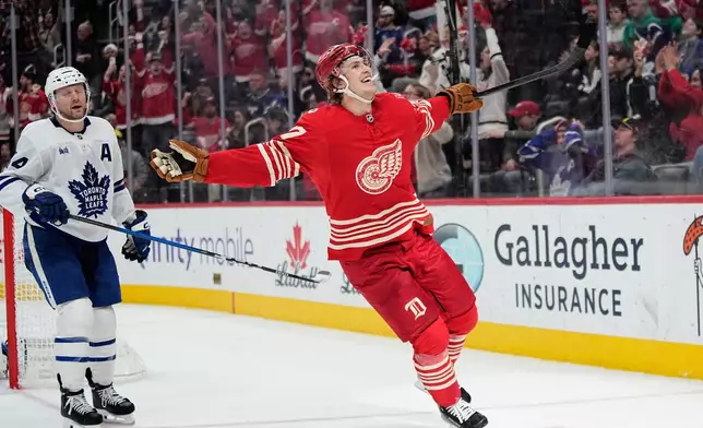 Detroit Red Wings defenseman Simon Edvinsson, right, celebrates near Toronto Maple Leafs defenseman Morgan Rielly, left, after scoring the winning goal during overtime of an NHL hockey game Sunday, Dec. 28, 2025, in Detroit. (AP Photo/Ryan Sun)