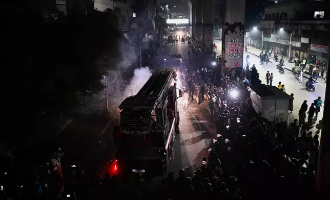 A fire engine arrives at the premises of The Daily Star newspaper after angry protesters set it on fire after news reached the country from Singapore of the death of a prominent activist Sharif Osman Hadi, in Dhaka, Bangladesh, Friday, Dec. 19, 2025. (AP Photo/Mahmud Hossain Opu)