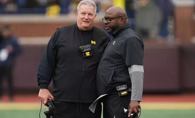 FILE - Michigan associate head coach Biff Poggi, left, talks with running backs coach Tony Alford talk during an NCAA college football spring game in Ann Arbor, Mich., Saturday, April 19, 2025. (AP Photo/Paul Sancya, File)