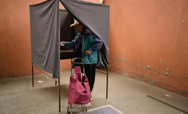 Luis Soto prepares to vote in the presidential runoff election in Santiago, Chile, Sunday, Dec. 14, 2025. (AP Photo/Natacha Pisarenko)