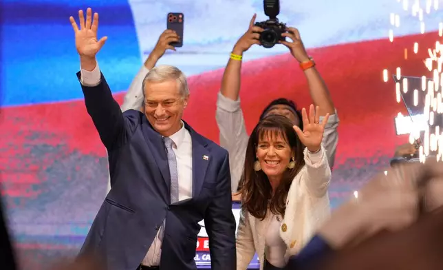 Presidential candidate Jose Antonio Kast, of the opposition Republican Party, and his wife Maria Pia Adriasola wave to supporters after winning the presidential runoff election in Santiago, Chile, Sunday, Dec. 14, 2025. (AP Photo/Matias Delacroix)