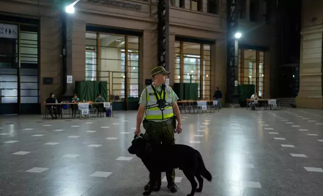Police guard the Mapocho station polling station during the presidential runoff election in Santiago, Chile, Sunday, Dec. 14, 2025. (AP Photo/Natacha Pisarenko)