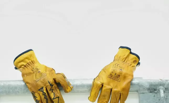 A worker's gloves and tool are lined up along the track ahead of a three-day skeleton and bobsled World Cup stage and Olympic test event in Cortina D'Ampezzo, Italy, Nov. 19, 2025. (AP Photo/Andrew Medichini, File)