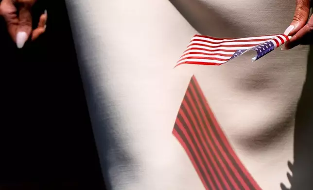 First lady Melania Trump holds an American flag while visiting Children's National Hospital, July 3, 2025, in Washington. (AP Photo/Julia Demaree Nikhinson, File)