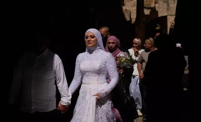 Just-married couple Eyad Othman and Aliza Ammash walk through Jerusalem's Old City, Oct. 11, 2025. (AP Photo/Emilio Morenatti, File)