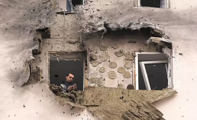 Investigators look at the damage of an apartment building where the downed Ukrainian drone fell in Sapronovo village outside Moscow, Russia, March 11, 2025. (AP Photo)