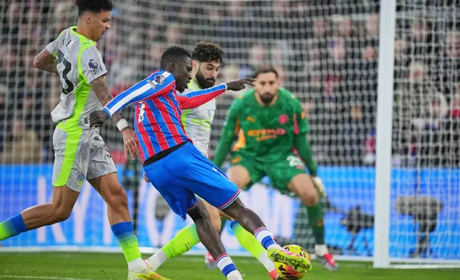 Crystal Palace's Ismaila Sarr, centre, makes an attempt to score during the English Premier League soccer match between Crystal Palace and Manchester City in London, Sunday, Dec.14, 2025. (AP Photo/Kin Cheung)