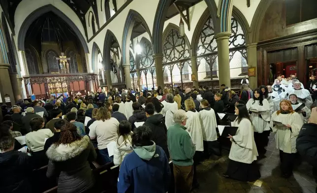The choir enters St. Stephen's Church during a community service for the victims of the Brown University shooting, Tuesday, Dec. 16, 2025. (AP Photo/Robert F. Bukaty)