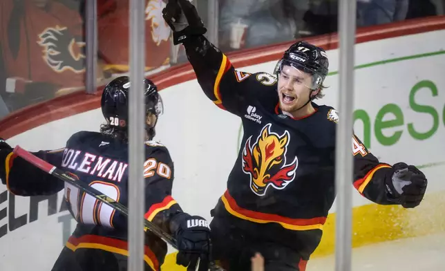 Calgary Flames' Connor Zary, right, celebrates his goal with teammate Blake Coleman during third period NHL hockey action against the Minnesota Wild in Calgary on Thursday, Dec. 4, 2025. (Jeff McIntosh/The Canadian Press via AP)