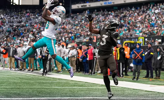 Miami Dolphins cornerback Rasul Douglas (26) intercepts a pass intended for New York Jets wide receiver John Metchie III (3) at the goal line during the second quarter of an NFL football game, Sunday, Dec. 7, 2025, in East Rutherford, N.J. (AP Photo/Yuki Iwamura)