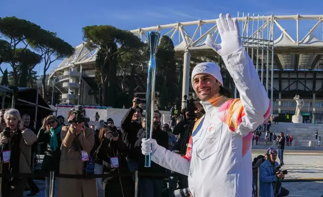 Italian high jumper and Olympic gold medalist Gianmarco Tamberi carries the 2026 Milan Cortina Winter Olympics torch in Rome as it begins its journey through Italy, Saturday, Dec. 6, 2025, a journey that will conclude in Milan in February 2026. (AP Photo/Andrew Medichini)