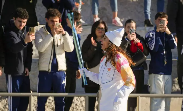 Italian former foil fencer and Olympic and world champion Elisa Di Francisca carries the 2026 Milan Cortina Winter Olympics torch in Rome as it begins its journey through Italy, Saturday, Dec. 6, 2025, a journey that will conclude in Milan in February 2026. (AP Photo/Andrew Medichini)
