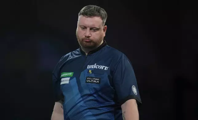 Cameron Menzies of Scotland reacts as he takes part in a round one match at the World Darts Championships, at Alexandra Palace in London, Monday, Dec. 15, 2025. (AP Photo/Kin Cheung)