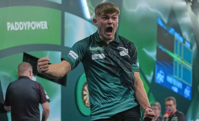 Charlie Manby of England celebrates as he takes part in a round one match at the World Darts Championships, at Alexandra Palace in London, Monday, Dec. 15, 2025. (AP Photo/Kin Cheung)