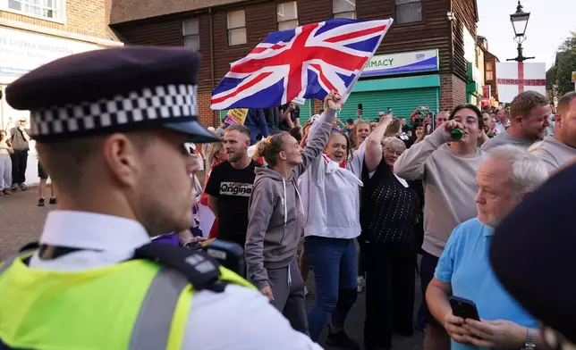 FILE - Protesters wave a Union Flag during a demonstration in Orpington near London, Friday, Aug. 22, 2025 as the dilemma of how to house asylum-seekers in Britain got more challenging for the government after a landmark court ruling this week motivated opponents to fight hotels used as accommodation. (AP Photo/Alberto Pezzali, File)