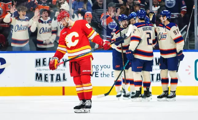 Calgary Flames' Joel Farabee (86) skates off as Edmonton Oilers players celebrate a goal during first period NHL action in Edmonton on Tuesday, Dec. 23, 2025. (Amber Bracken/The Canadian Press via AP)